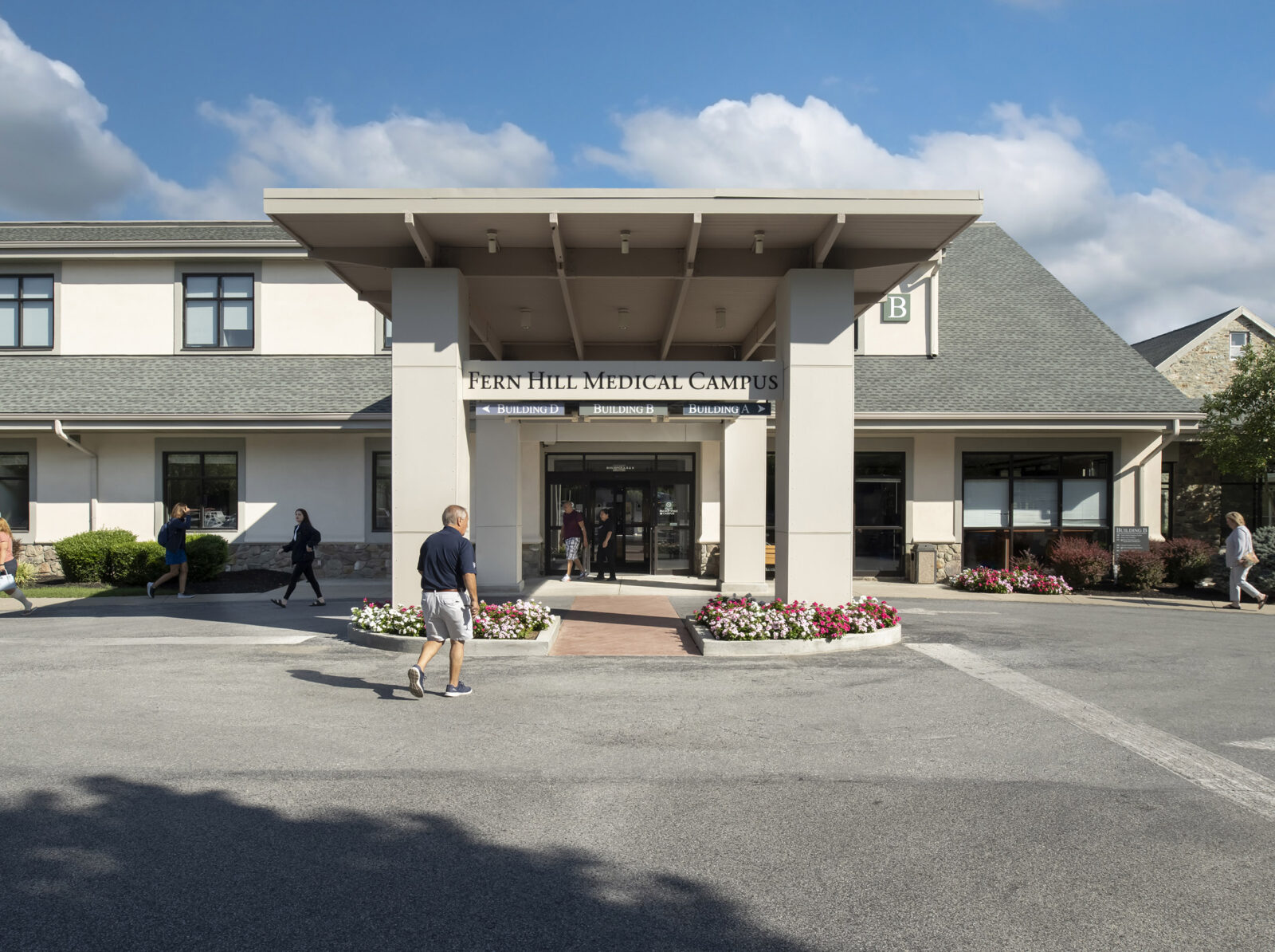 photo of the medical campus's porte cochere, people flow in and out of the building