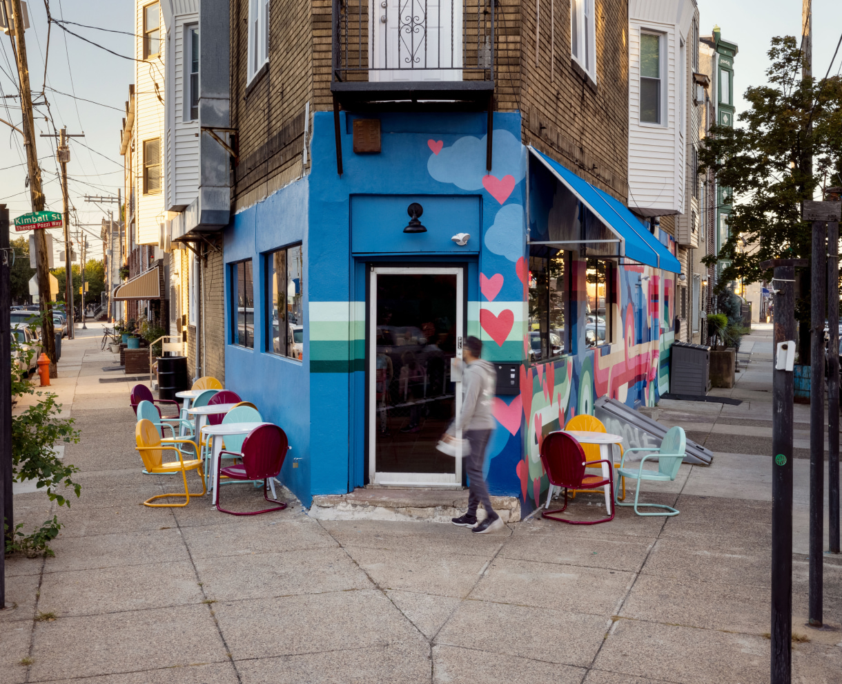 Tacoheart exterior with outside tables/chairs. A person is walking into Tacoheart