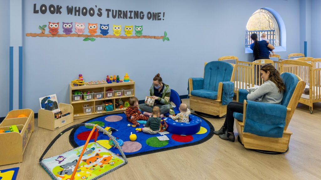 Babies are playing with teachers at a daycare center