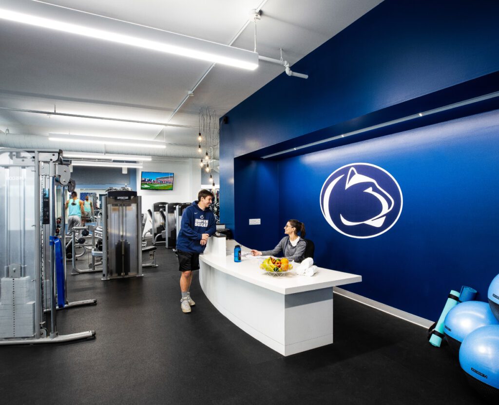 Penn State Athletic Center Gym with two people talking to each other at a front desk