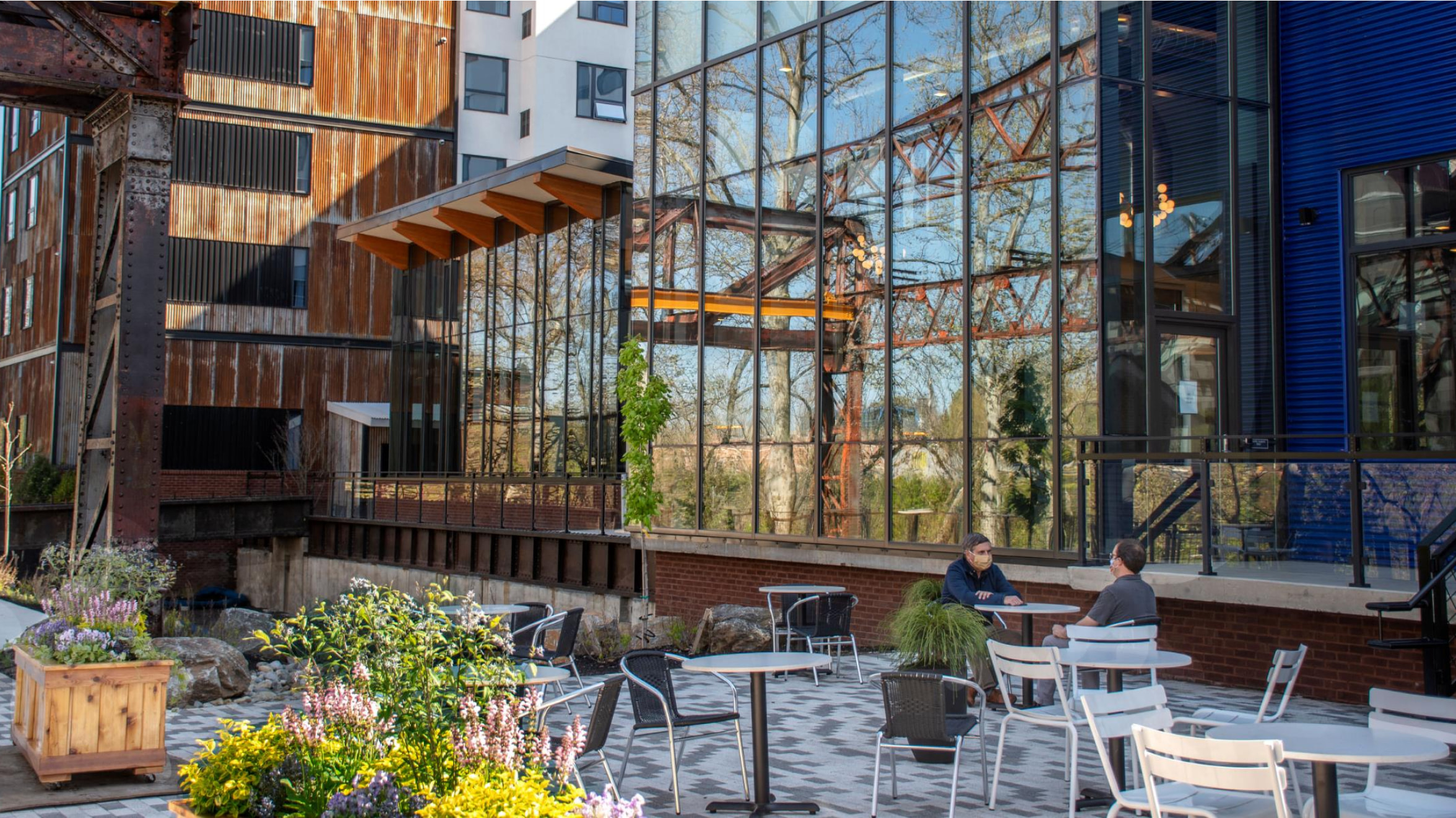 Pencoyd outside patio with two people chatting while sitting on chairs