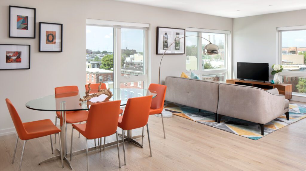 The Royer living room and dining table with orange-colored chairs