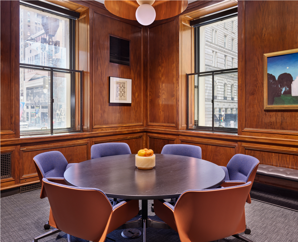 A meeting area with a round table and chairs around it.