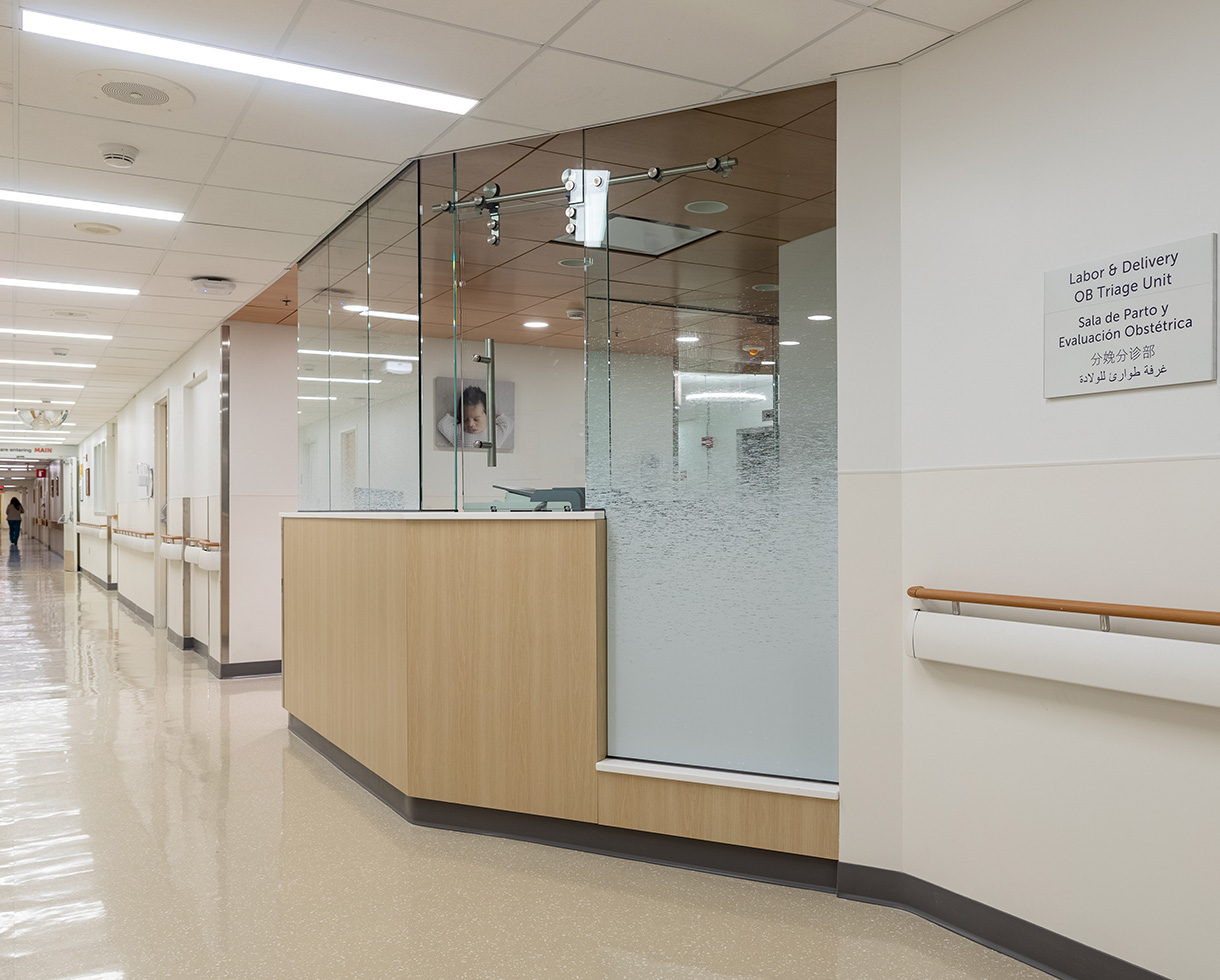 view of the entrance in the hospital hallway. a frosted glass wall provides visual interest and privacy