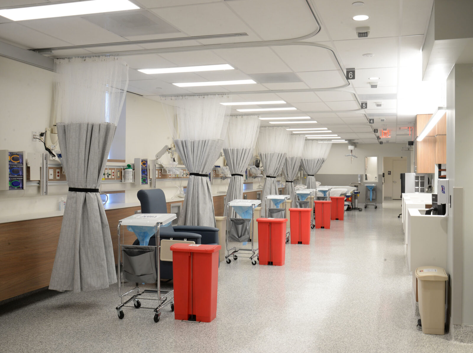 row of chairs and dialysis equipment, separated by privacy curtains